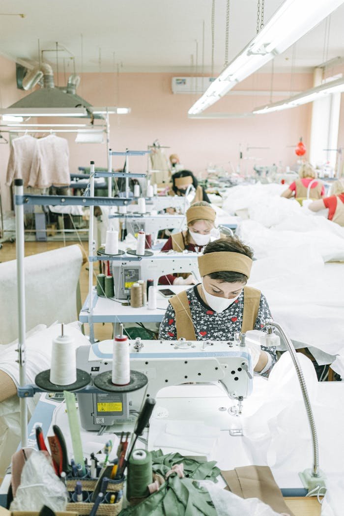 Women working with sewing machines in a textile factory, focused on production.